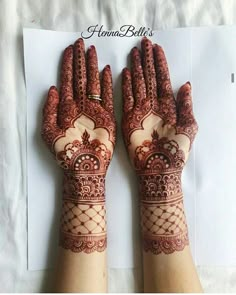 two hands with henna designs on them