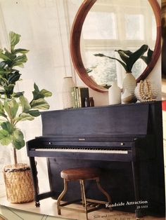 a piano sitting in front of a mirror next to a potted plant