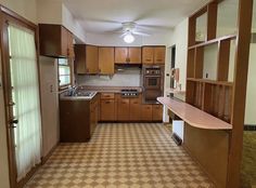 an empty kitchen with wood cabinets and tile flooring in the middle of the room