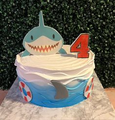 a birthday cake with a shark and number four on it