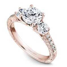 three stone engagement ring in rose gold with diamonds on the band and side stones around the band