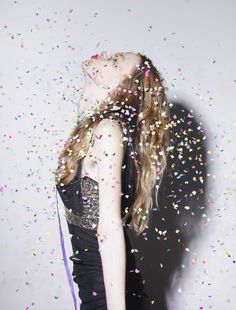 a woman standing under confetti falling from her hair