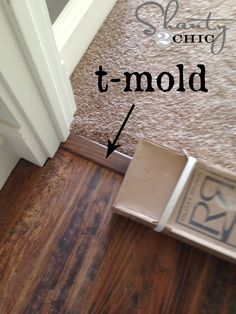 an open door with the word t - mol on it next to a wooden floor