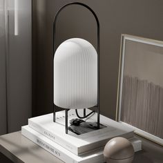 a white lamp sitting on top of a table next to a book and an egg