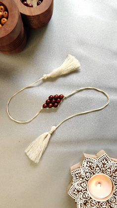 two wooden bowls with beads and tassels next to each other on a table