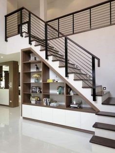 the stairs are built into the wall next to the bookshelf in this modern home