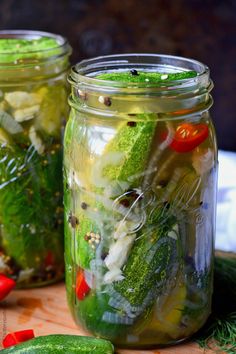 two mason jars filled with pickles, cucumbers and other veggies