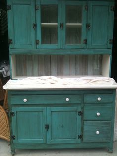 an old china cabinet is painted teal green