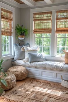 a window seat with pillows on it in a room filled with windows and rugs