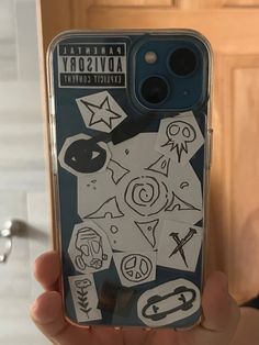 someone holding up their phone case with stickers on it