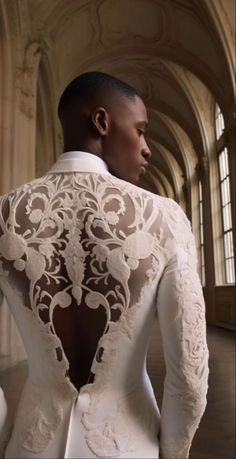 the back of a man in a white suit with an intricate lace design on it