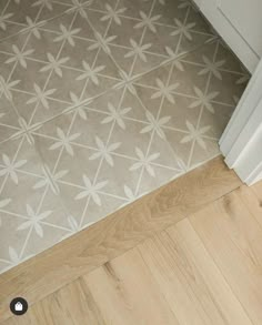 a bathroom floor with white and gray tiles on it's sides, next to a door