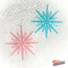 two plastic snowflakes sitting in the snow