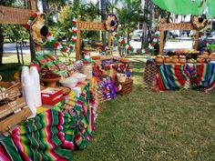 a table covered in colorful cloths under a green umbrella