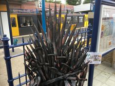 a large iron throne sitting on top of a sidewalk next to a train station platform