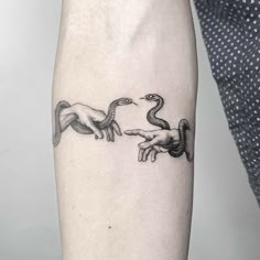 the creation of adam and eve tattoo on the left inner arm, with hands reaching out to each other