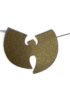 a gold and white necklace hanging from a string on a white background, with the shape of a heart cut in half