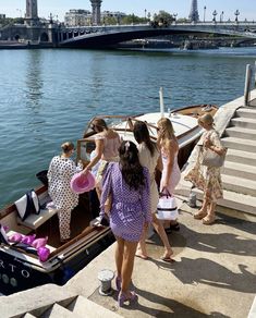 several women are boarding a boat on the water