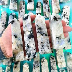 a person is holding several pieces of white and black rock with blue crystals on them