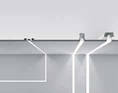 three lights are hanging from the ceiling in an empty room with white walls and flooring