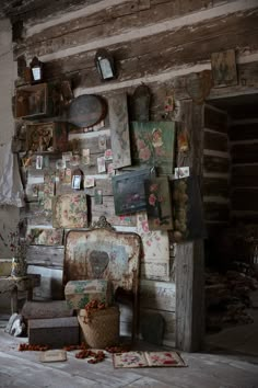 an old chair sitting in front of a wall with pictures and other items on it