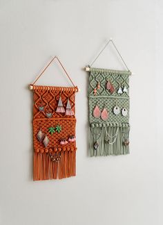 two wall hangings made out of yarn and wood with bead decorations on them