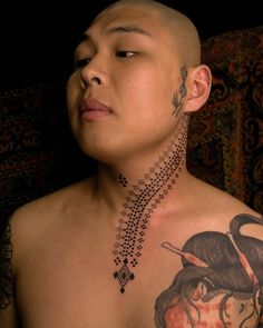 a man with tattoos on his chest and neck