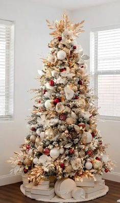 a white christmas tree with red and gold ornaments