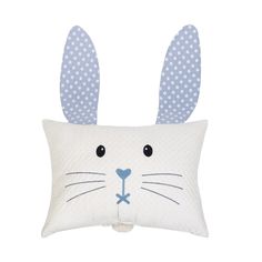 a white pillow with blue polka dots and a bunny face on the front of it