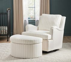 a white chair and ottoman in a room with a baby crib next to it