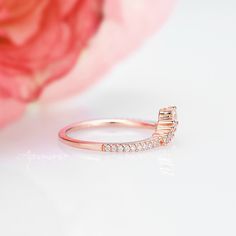 a diamond ring sitting on top of a pink flower