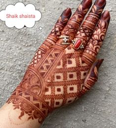 a henna on someone's hand that is showing the intricate designs and colors