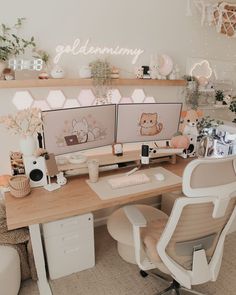 two computer monitors sitting on top of a wooden desk next to a white chair and potted plants