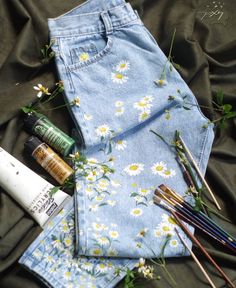 an assortment of paint, brushes and other items laid out on a cloth