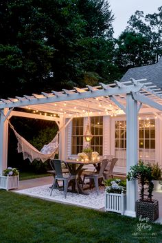 an outdoor dining area is lit up with string lights