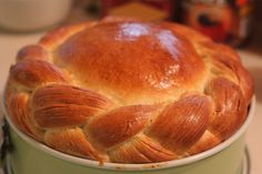 a baked bread in a green pot on a counter