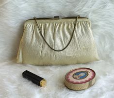 "This sweet vintage shiny, gold lame \"Ande\" clutch/handbag is in perfect vintage condition!  The inside features an amber colored satin and has two interior compartments. One compartment has a small pocket. It has a short metal strap that can tuck inside to convert to a clutch. The top of the center compartment is gold metal and it closes with a gold clasp on top.   -Measurements:   -Height: 6 1/2 inches   -Length: 10 inches For more lovely handmade, vintage and vintage-inspired items, visit our shop: www.etsy.com/shop/MadeleinesCollection" Retro Gold Clutch Bag, Gold Retro Clutch Bag, Mid-century Gold Evening Bag, Retro Gold Evening Bag, Vintage Gold Clutch For Everyday Use, Retro Gold Bag As A Gift, Gold Handbag, Gold Evening Bag, Gold Lame