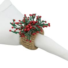 a white napkin with red berries and green stems on it's edge is being held by a hand