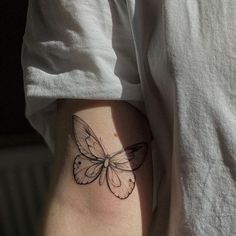 a small butterfly tattoo on the thigh