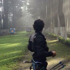 a man with a back pack on walking towards an archery target in the foggy woods