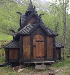 a small wooden building with a steeple on it's roof in the woods