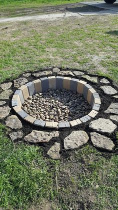 a fire pit made out of stones in the grass