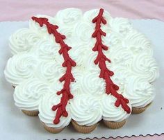 a cupcake decorated with white frosting and red laces is shown in the shape of a baseball