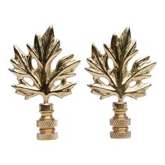 pair of gold toned metal leaves on top of each other, set against a white background