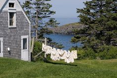 clothes hanging out to dry on a line in front of a house by the water