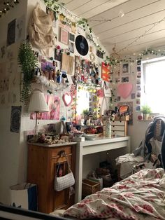 a bed room with a neatly made bed and lots of pictures on the wall above it