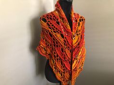 a crocheted shawl draped over a mannequin