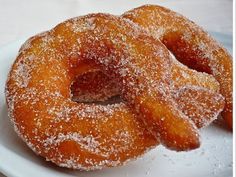 two sugar covered donuts on a white plate