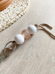 a keychain with three eggs on it sitting on a table next to a potted plant