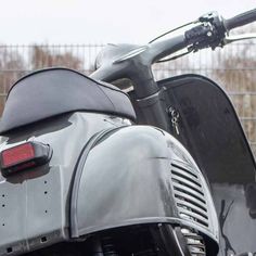 the back end of a motorcycle parked in front of a fence